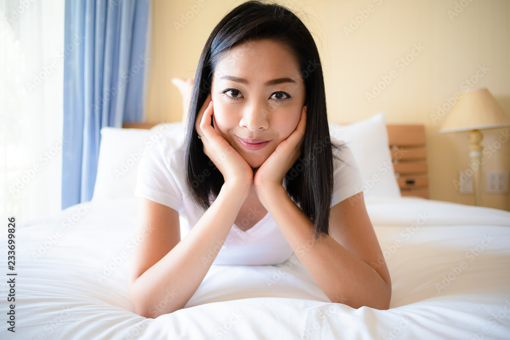 Happy woman relax on the bed with morning light. Happy woman relax on the bed with morning light.