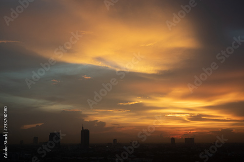 Golden sunset of cloudy sky over the city.