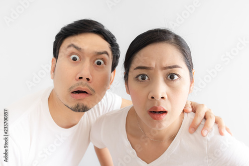 Funny face of lovers couple in doubt at an unbelievable thing that they are looking at photo