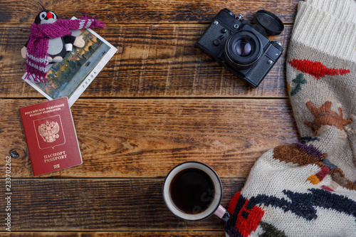 Accessories for travel plans, vacation trips, tourism - warm sweater and camera on a wooden background.Flat place and copy space.