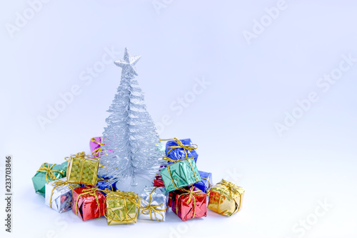 Decorative Christmas tree and gift boxes on fluffy snow.