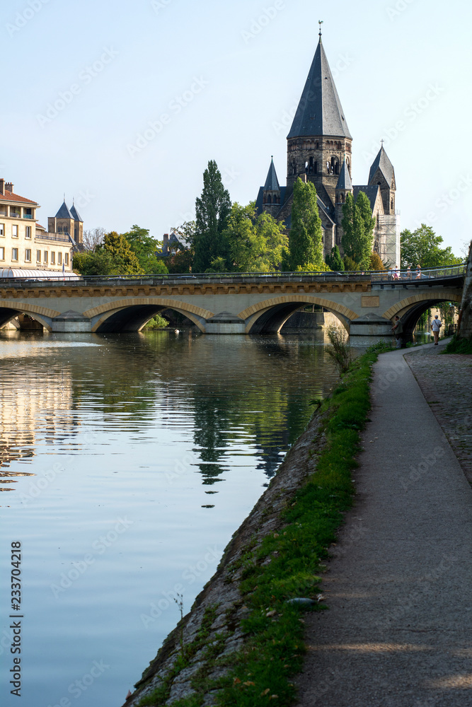 Ancient french castle near the bridge and river in the summer day under the blue sky in Metz