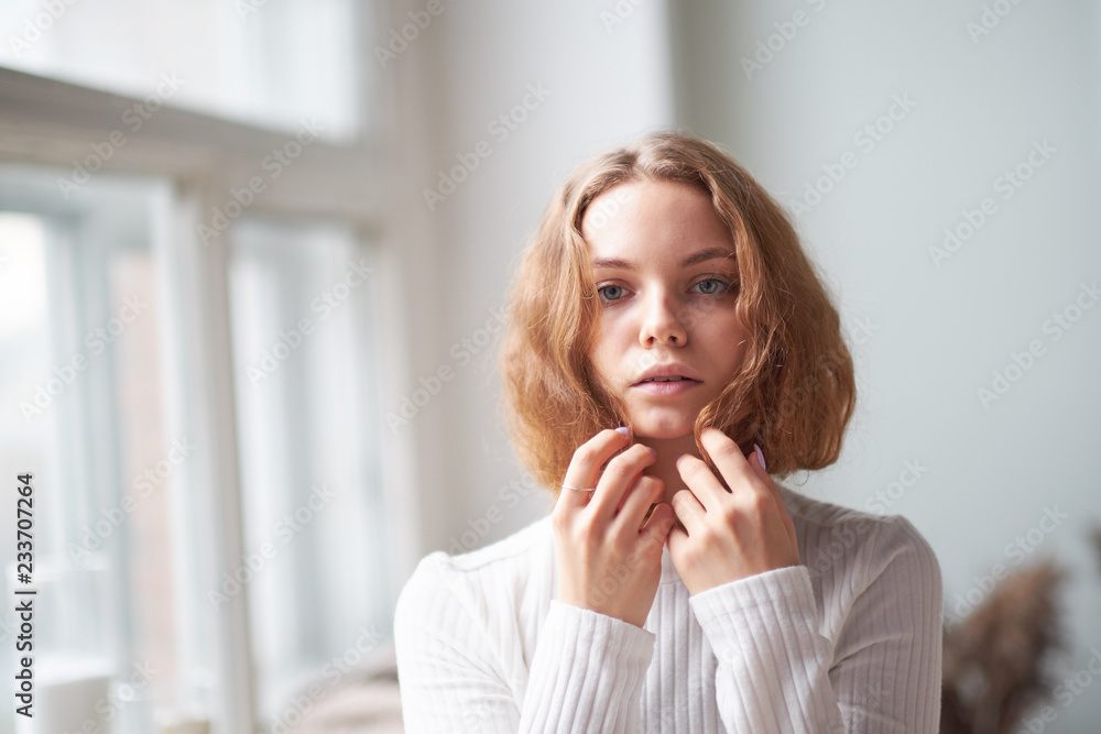 portrait of a beautiful curly girl. the mysterious face of a woman at the window. portrait of a beautiful curly girl. the mysterious face of a woman at the window.