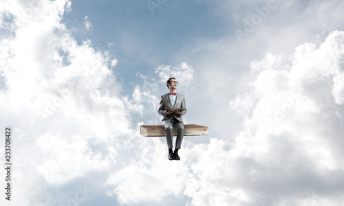 Wallpaper Mural Young businessman or student floating in blue sky and studying the science Torontodigital.ca