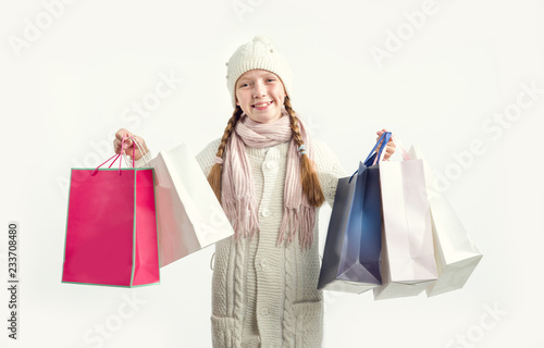 Girl with gift bags on a light background. Shopping before Christmas.