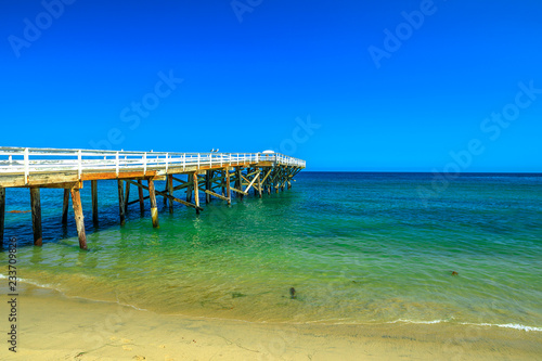 Fototapeta Naklejka Na Ścianę i Meble -  Paradise Cove Pier, a wooden pier in Paradise Cove beach, Malibu, California, United States. Wallpaper turquoise waters, copy space. Luxurious travel destination on Pacific Coast. Summer blue sky.