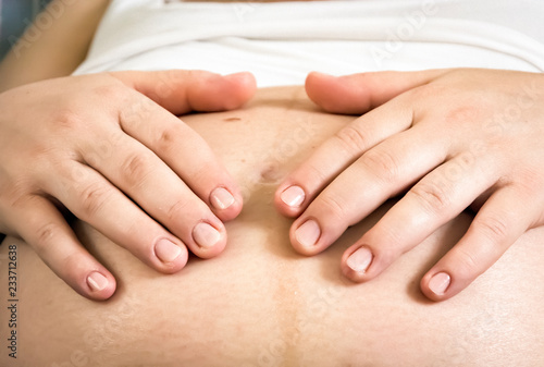 Hands of a pregnant woman caressing her belly