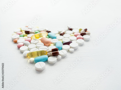 pills mix in a heart shape. painkillers and prescription drugs on white background