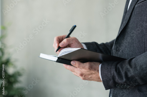 man hand writing in notebook. business planning or agenda concept.