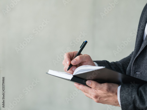 man hand writing in notepad. agenda or scheduled control of business affairs. photo