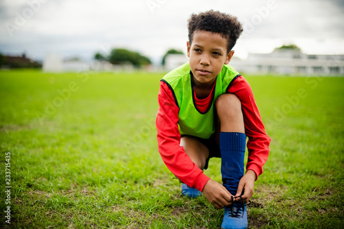 Bilde på lerret Junior football player tying his shoelaces