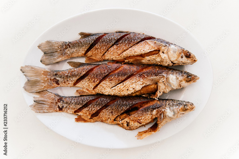 Thai style deep fried fishes on white plate, Top view Thai style deep fried fishes on white plate, Top view