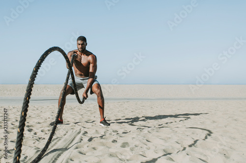 Fit man working out with battle ropes photo