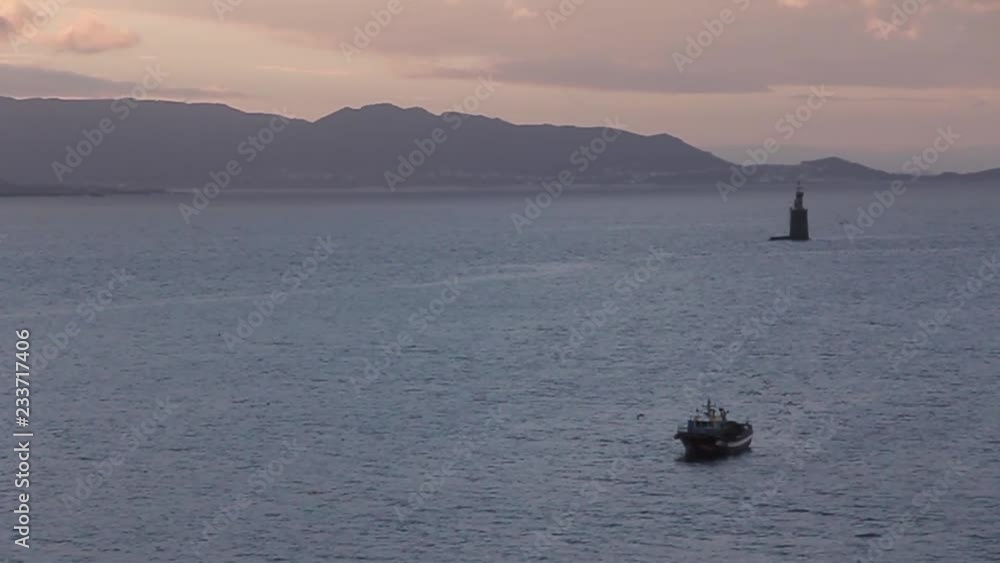Barco de pesca llegando a la costa al amanecer Barco de pesca llegando a la costa al amanecer