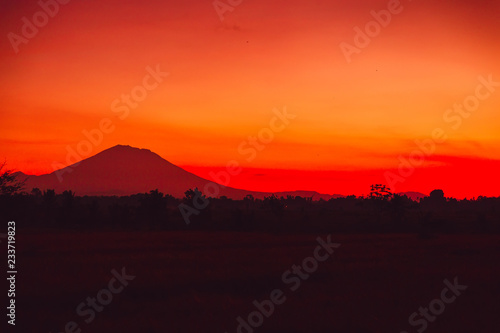 Bright colorful sunrise with silhouette of volcano in Bali © artifirsov