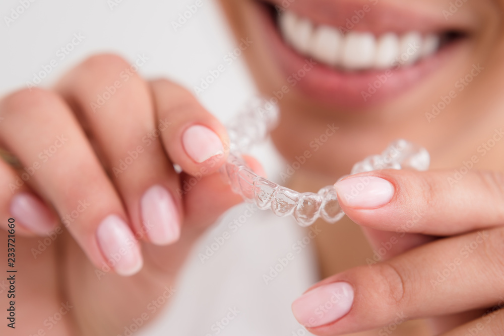girl with a beautiful smile holding a transparent mouth guard girl with a beautiful smile holding a transparent mouth guard