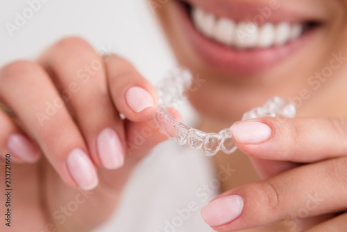 girl with a beautiful smile holding a transparent mouth guard
