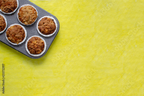 Fresh baked muffins on bright yellow background