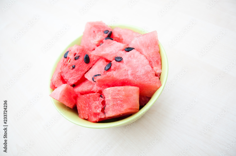 Fresh watermelon in green bowl on wooden table Fresh watermelon in green bowl on wooden table