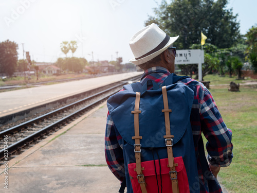 Back side of Senior man Asian with backpack are walking at train station. Travel, Tourist, holiday and lifestyle Concept