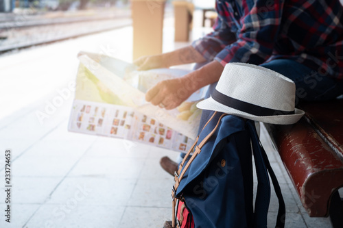 Backpack and hat Background Senior man Asian look searching direction on location map at the train station for plan to travel. Tourist, holiday and lifestyle Concept..