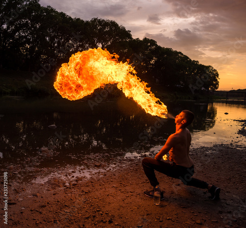 Fotografia Fire-eater blowing a large flame from his mouth