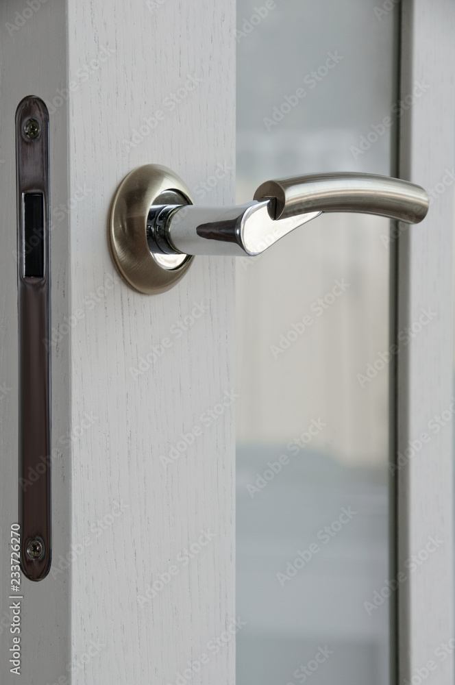 Closeup photo of metal door handle in modern style Closeup photo of metal door handle in modern style