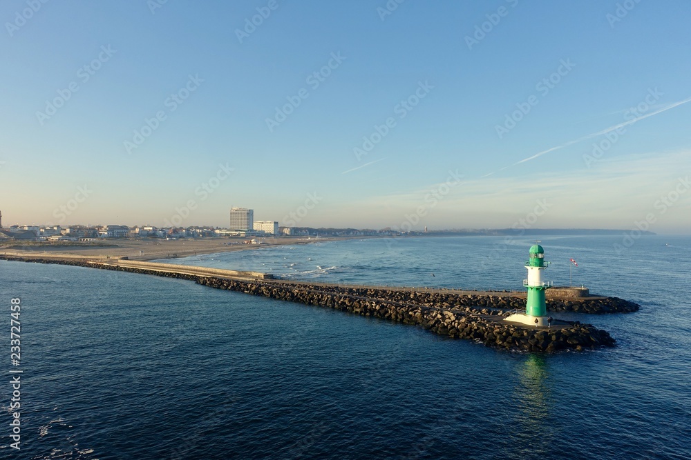 einfahrt mit dem schiff in den hafen Rostock Warnemünde mit blick auf die mole strand und den grünen leuchtturm