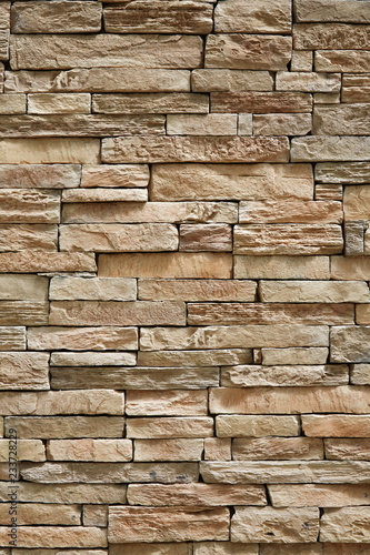 Wall of stone beige surface bricks as a background.