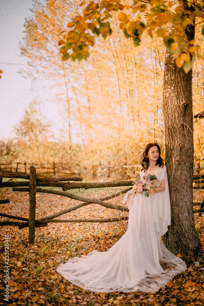Bride in style boho stand on background of autumn nature Bride in style boho stand on background of autumn nature