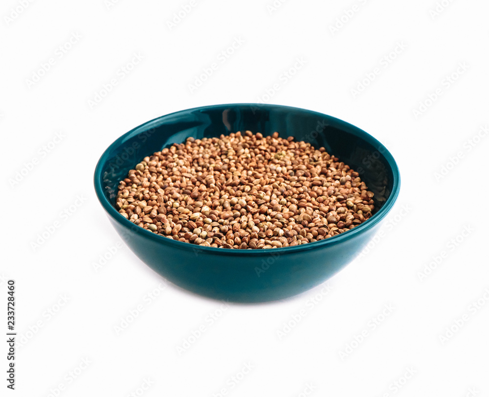 Cannabis seeds in a blue bowl, isolated on white background. Marijuana grains in a plate, herbal health treatment. Cannabis seeds in a blue bowl, isolated on white background. Marijuana grains in a plate, herbal health treatment.