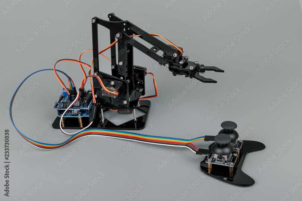 small robot arm with joystick on gray background small robot arm with joystick on gray background