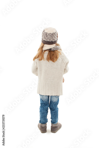 Back view of beautiful caucasian blonde fashionable girl in warm cloth looking at wall. Winter style. Isolated on white background.