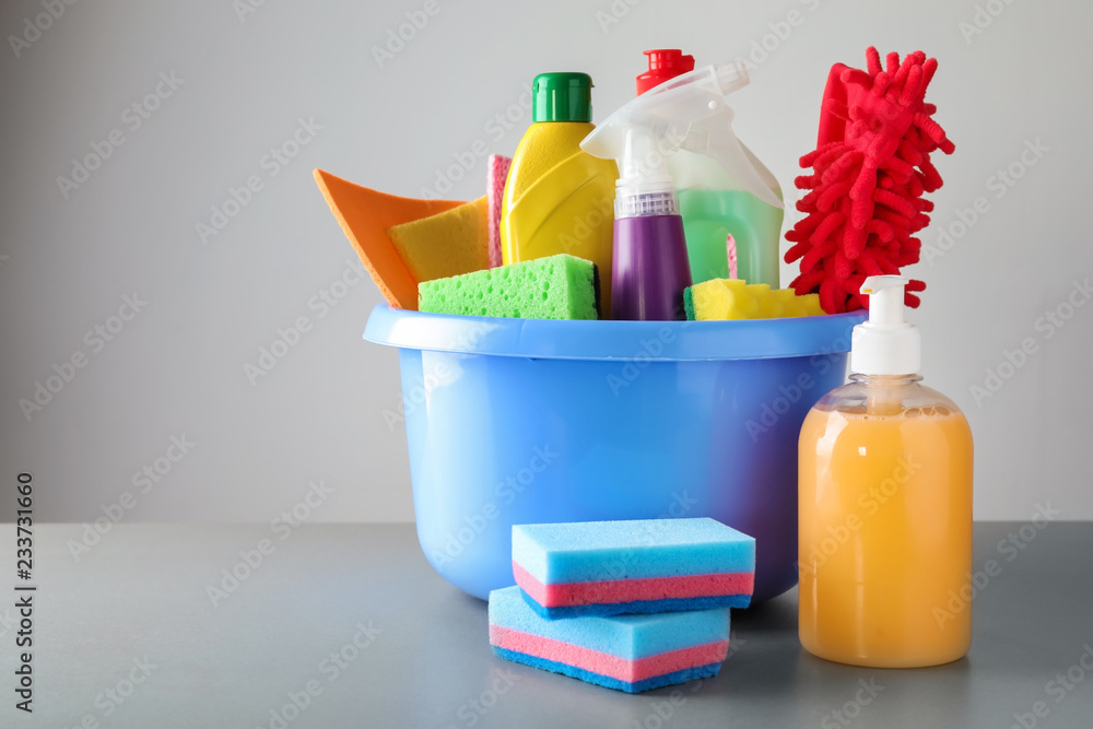 Basin with cleaning supplies on table Basin with cleaning supplies on table