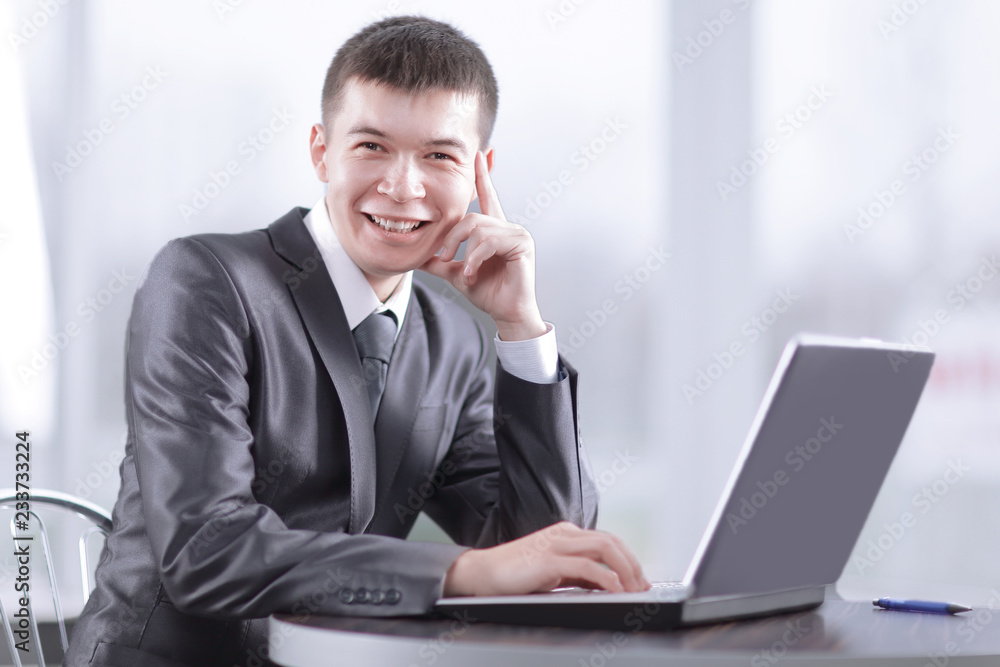 close up.smiling businessman sitting in front of open laptop close up.smiling businessman sitting in front of open laptop
