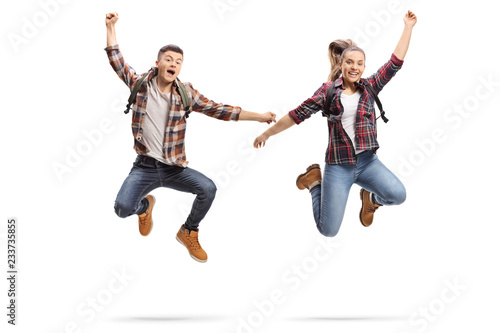 Happy male and female students jumping