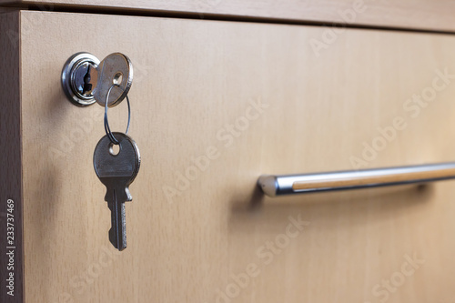 The key in the keyhole of the desk drawer