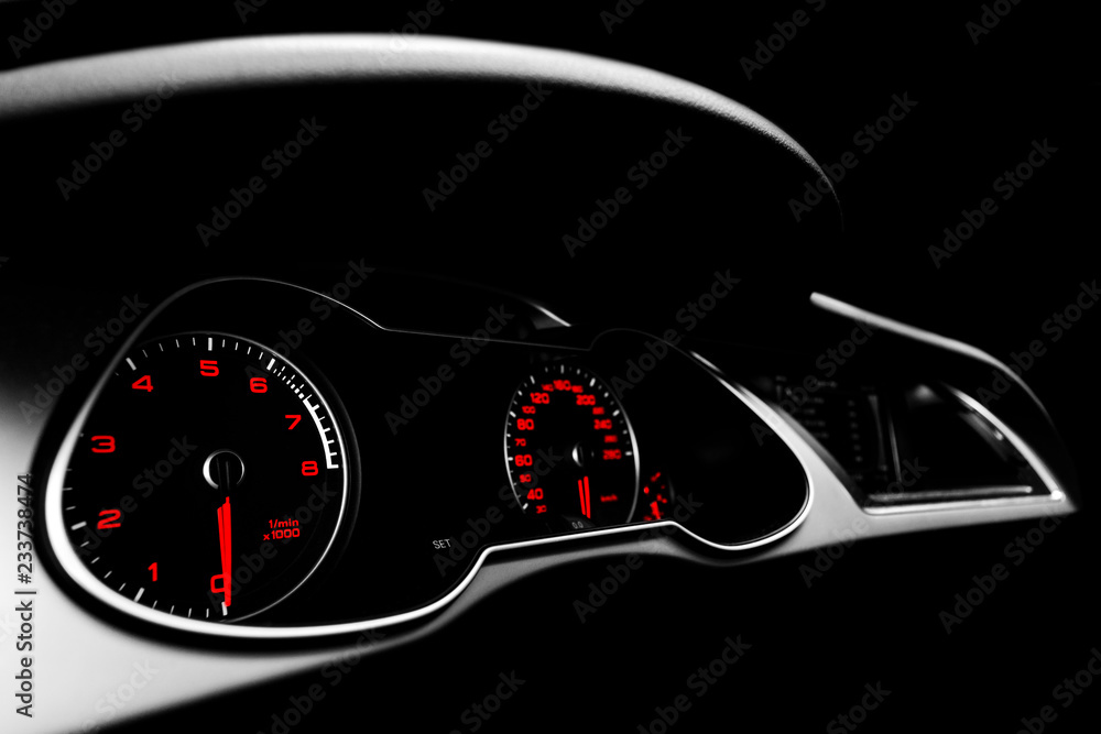 Close up shot of a speedometer in a car. Car dashboard. Dashboard details with indication lamps.Car instrument panel. Dashboard with speedometer, tachometer, odometer. Car detailing. Black and white