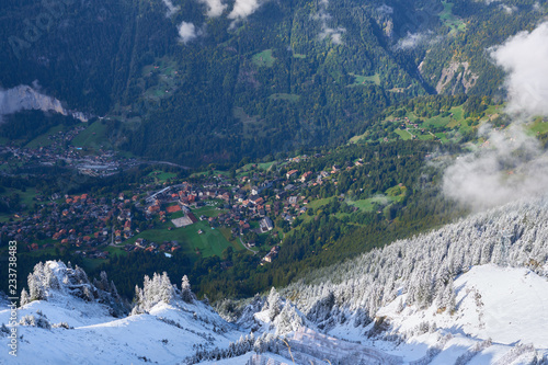 Aerial view of Wengen village in the green mountain valley with fresh snow on the slopes. Lauterbrunnen region in Switzerland.