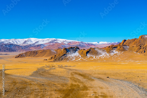 Mountain landscape in summer with the large yellow steppe and the hill at Ulgii in Mongolia