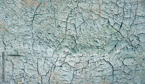Abstract blue, beige and turquoise background wallpaper texture. Old flaky paint peeling off grungy cracked wall. Cracks, scrapes, peeling old paint and plaster on background of old cement wall.