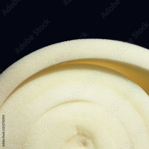 Roll white foam rubber texture isolation on a black background. Polystyrene sealing foam surface background. Insulation material close-up