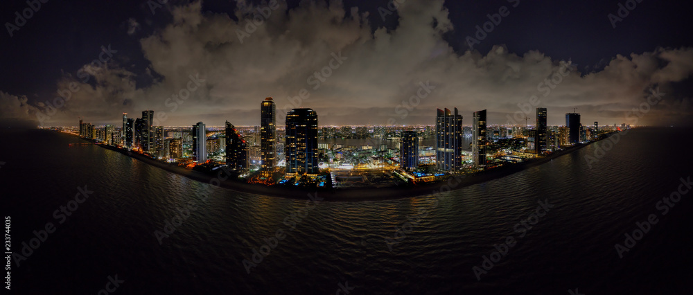 Fototapeta premium Aerial night drone panoramac photo coastal city highrise tower illuminated