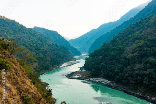 Obraz na płótnie Spectacular view of the sacred Ganges river flowing through the green mountains of Rishikesh, Uttarakhand, India. w salonie