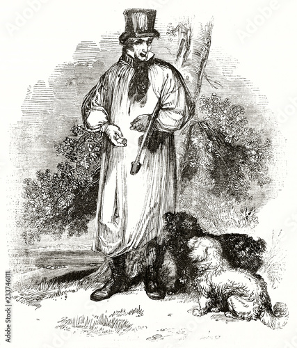Ancient truffle searcher depicted full body posing with his dogs. He wears a long coat, a cilinder and he holds a stick. By unidentified author published on Magasin Pittoresque Paris 1839