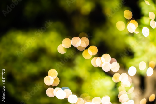Beautiful bokeh of colorful Christmas lights in a city (Blurry background of illumination and decoration of trees in holiday night)