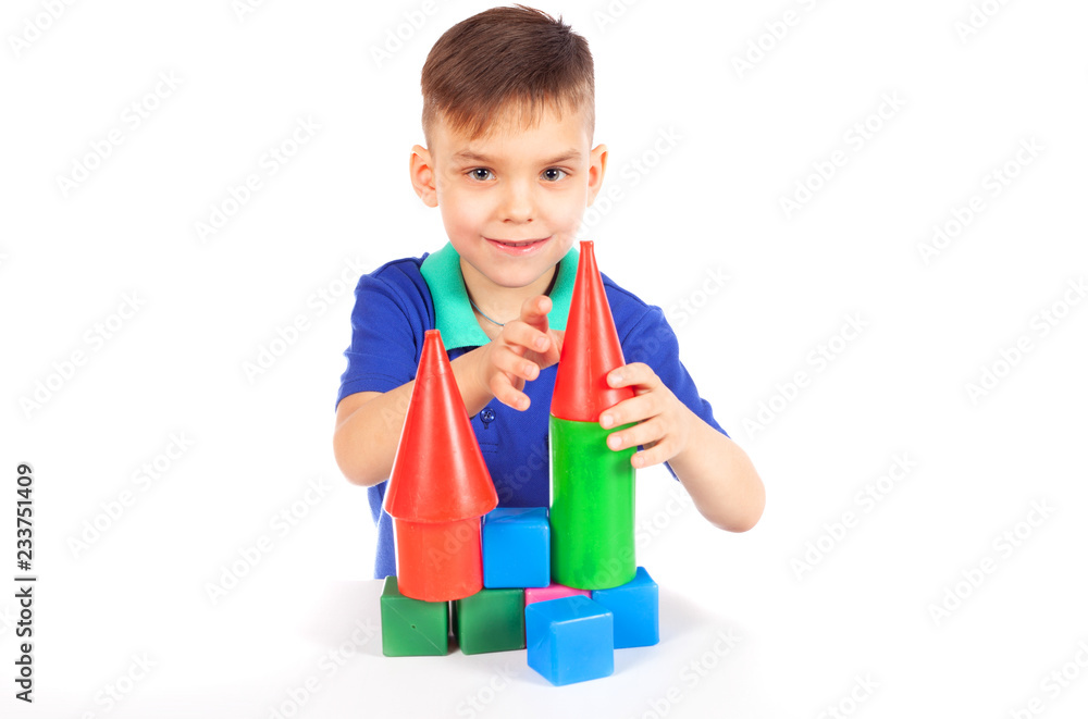 The boy builds a house of cubes - isolated on white The boy builds a house of cubes - isolated on white