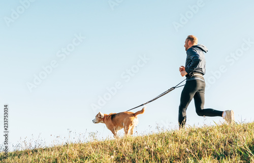 Morning Canicross exercise. Man runs with his beagle dog. photo