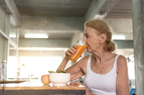 Senior woman eating healthy salad and orange juice. elderly health lifestyle concept.