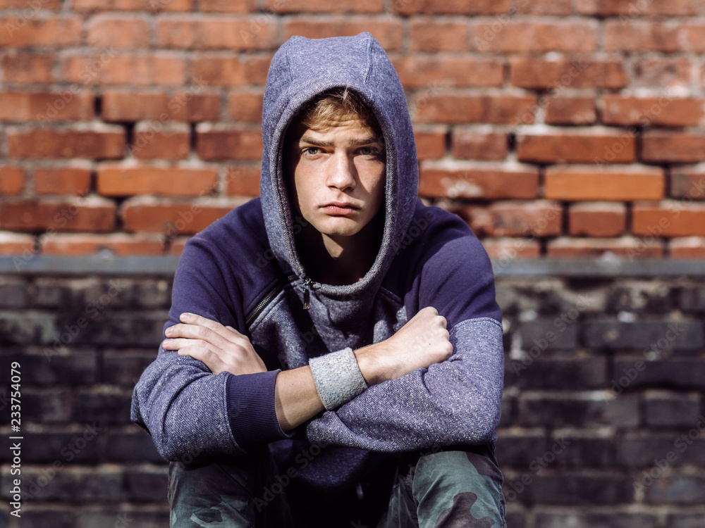 © polya_olya - dangerous teenager on brick wall background, teen problems concept © polya_olya - dangerous teenager on brick wall background, teen problems concept